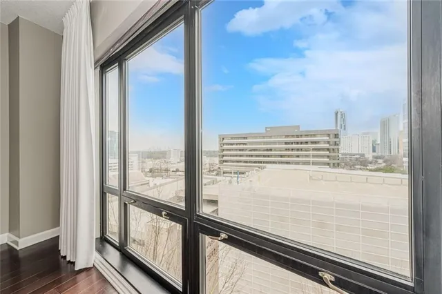 a view of a kitchen and an empty room with wooden floor