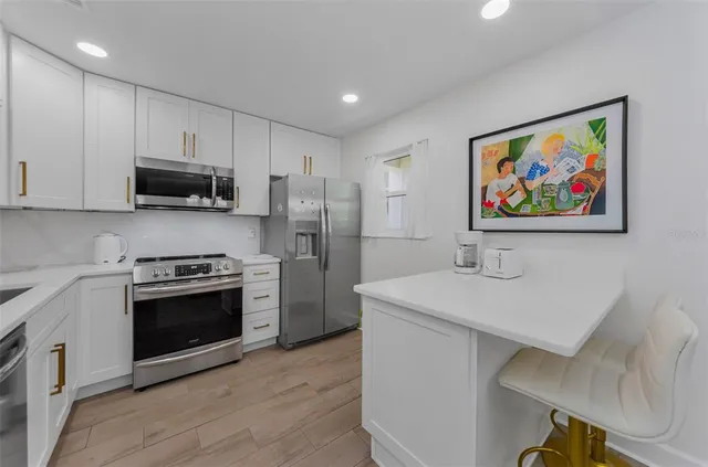 a kitchen with stainless steel appliances a stove a refrigerator and a sink
