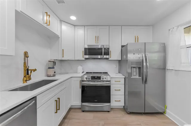 a kitchen with a stove sink and refrigerator