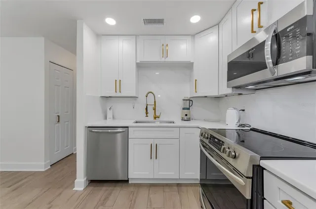 a kitchen with stainless steel appliances granite countertop a wooden cabinets and a stove top oven