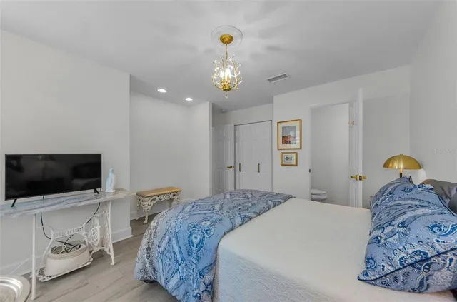 a bedroom with a large bed and a flat tv screen on dresser