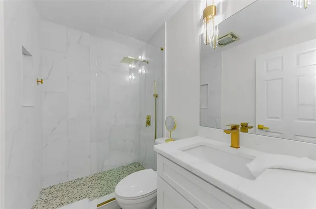 a bathroom with a sink a toilet and shower