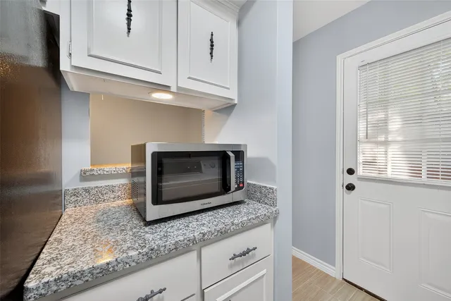a kitchen with granite countertop a stove microwave and sink
