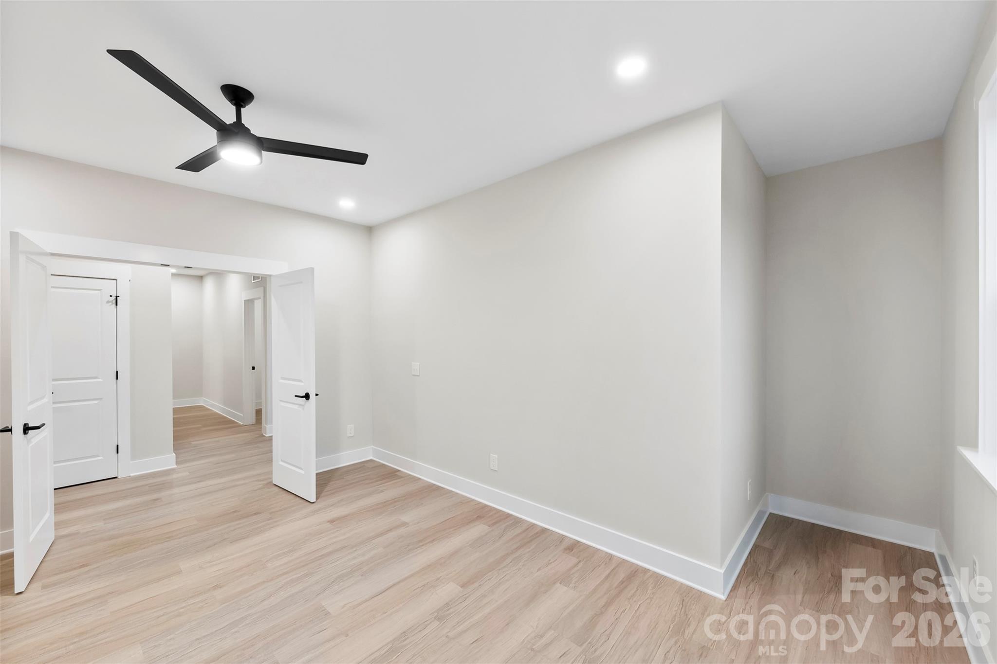 551 Perry Road Troutman, NC 28166 - Photo 25 of 47 an empty room with wooden floor and a ceiling fan