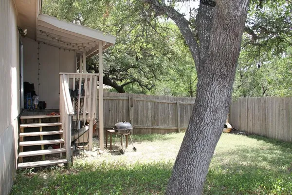 a view of a patio with table and chairs and a large tree