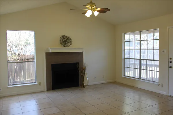 a view of an empty room with a fireplace and a window