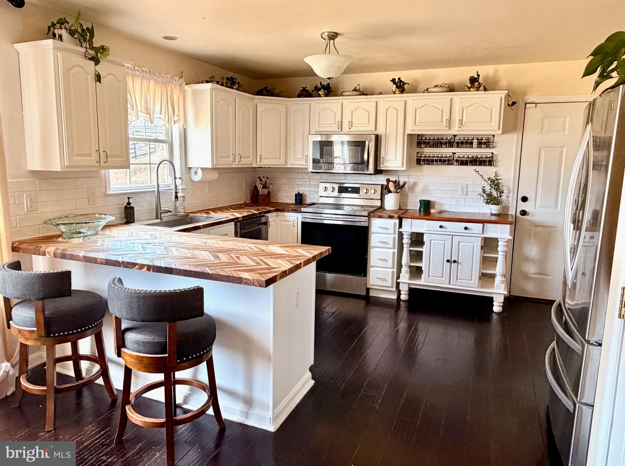 13028 Dreamers Path Culpeper, VA 22701 - Photo 7 of 13 a kitchen with stainless steel appliances a stove a sink dishwasher a refrigerator white cabinets and wooden floor