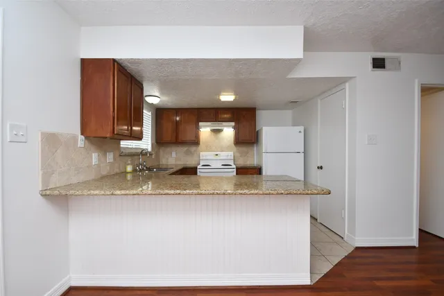 a kitchen with refrigerator and stove
