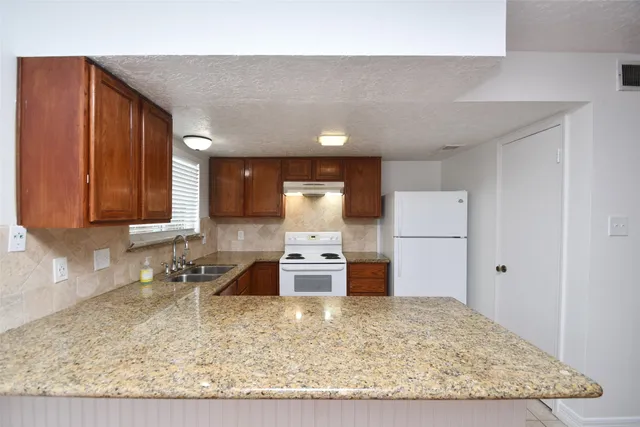 a kitchen with sink a stove and cabinets