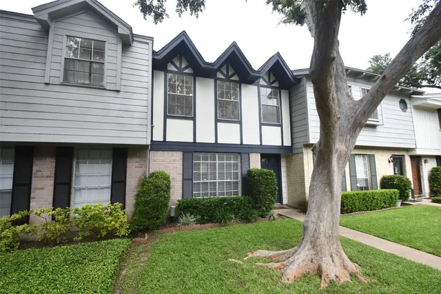 a front view of a house with a yard and trees