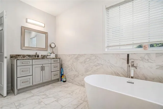 a spacious bathroom with a tub sink and mirror