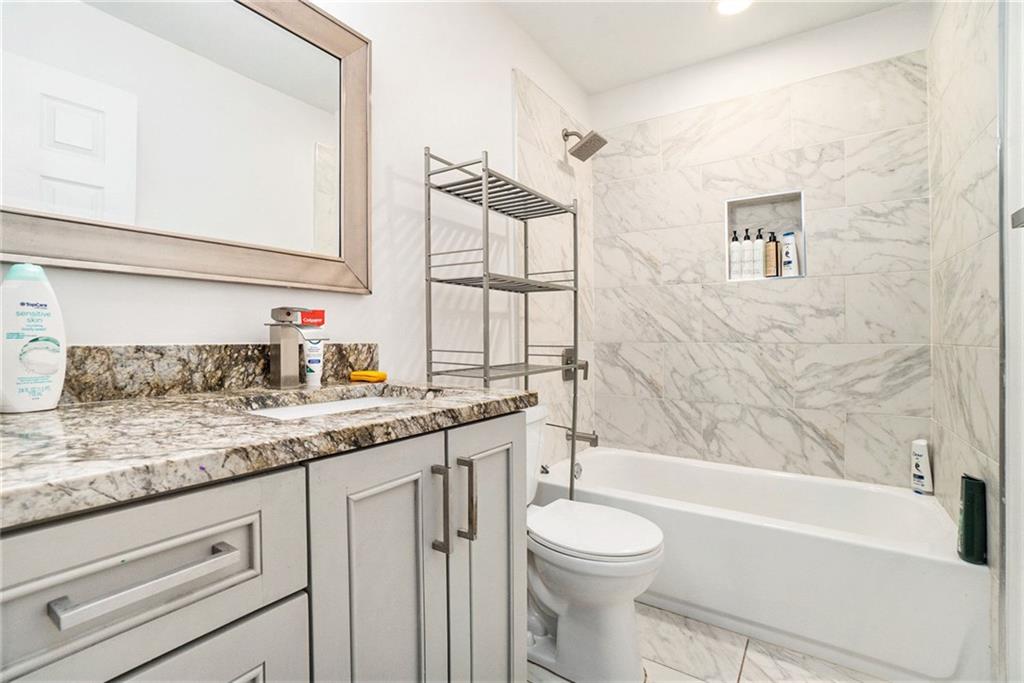 2798 Glenlocke Circle Northwest Atlanta, GA 30318 - Photo 18 of 24 a bathroom with a granite countertop sink a toilet and bathtub