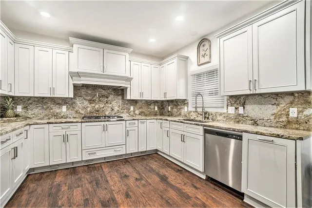 a kitchen with granite countertop cabinets stainless steel appliances and a sink