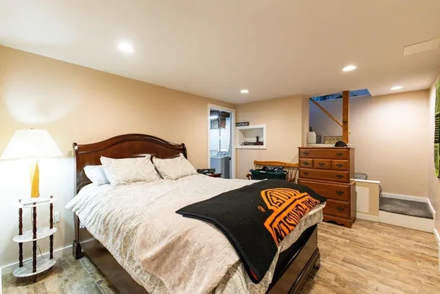 a bedroom with bed and wooden floor