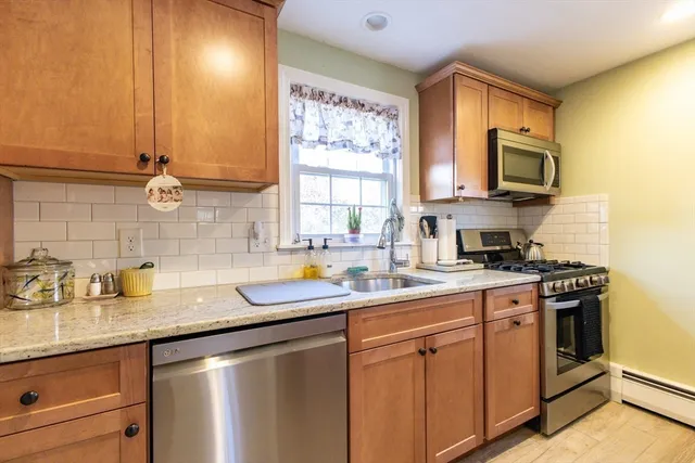 a kitchen with stainless steel appliances granite countertop a sink a stove and a microwave