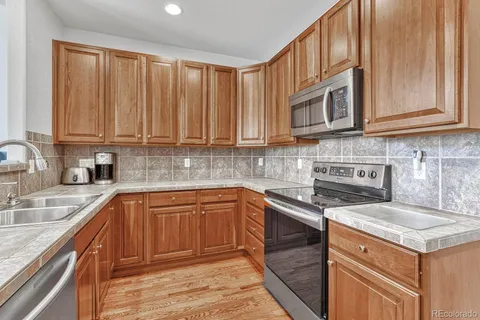 a kitchen with stainless steel appliances granite countertop a sink stove and cabinets