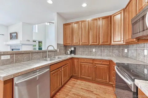 a kitchen with stainless steel appliances granite countertop a sink stove and cabinets
