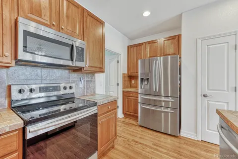 a kitchen with a refrigerator stove and wooden cabinets