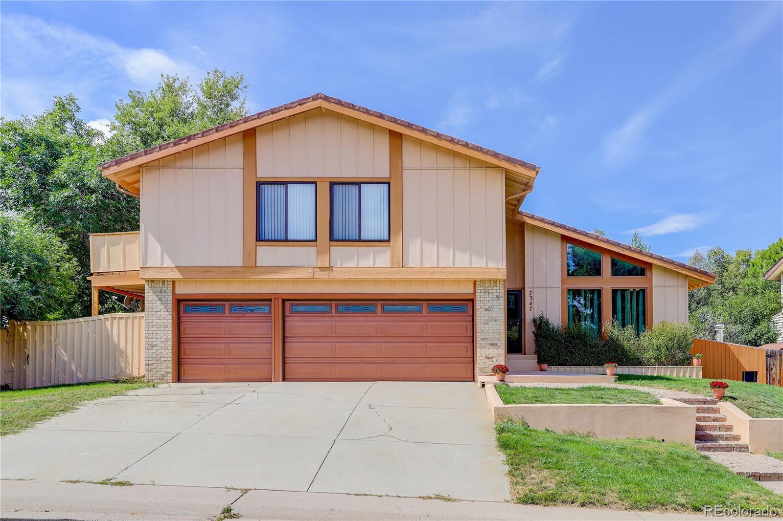 7347 South Ridgeview Drive Littleton, CO 80120 - Photo 1 of 36 a front view of a house with a yard and garage