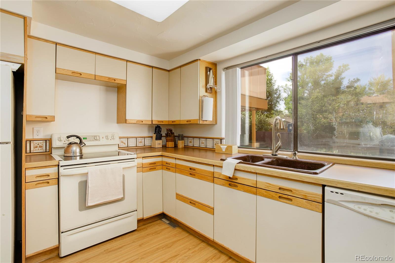 7347 South Ridgeview Drive Littleton, CO 80120 - Photo 12 of 36 a kitchen with a sink and white cabinets