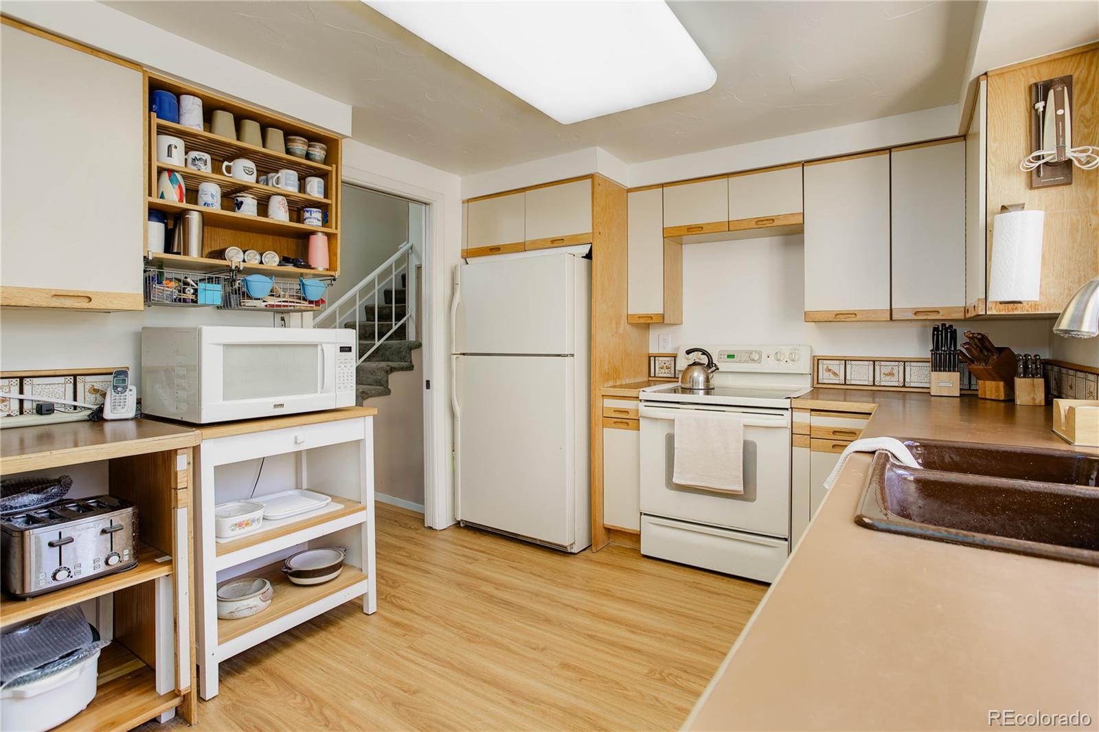 7347 South Ridgeview Drive Littleton, CO 80120 - Photo 13 of 36 a kitchen with a refrigerator and white cabinets