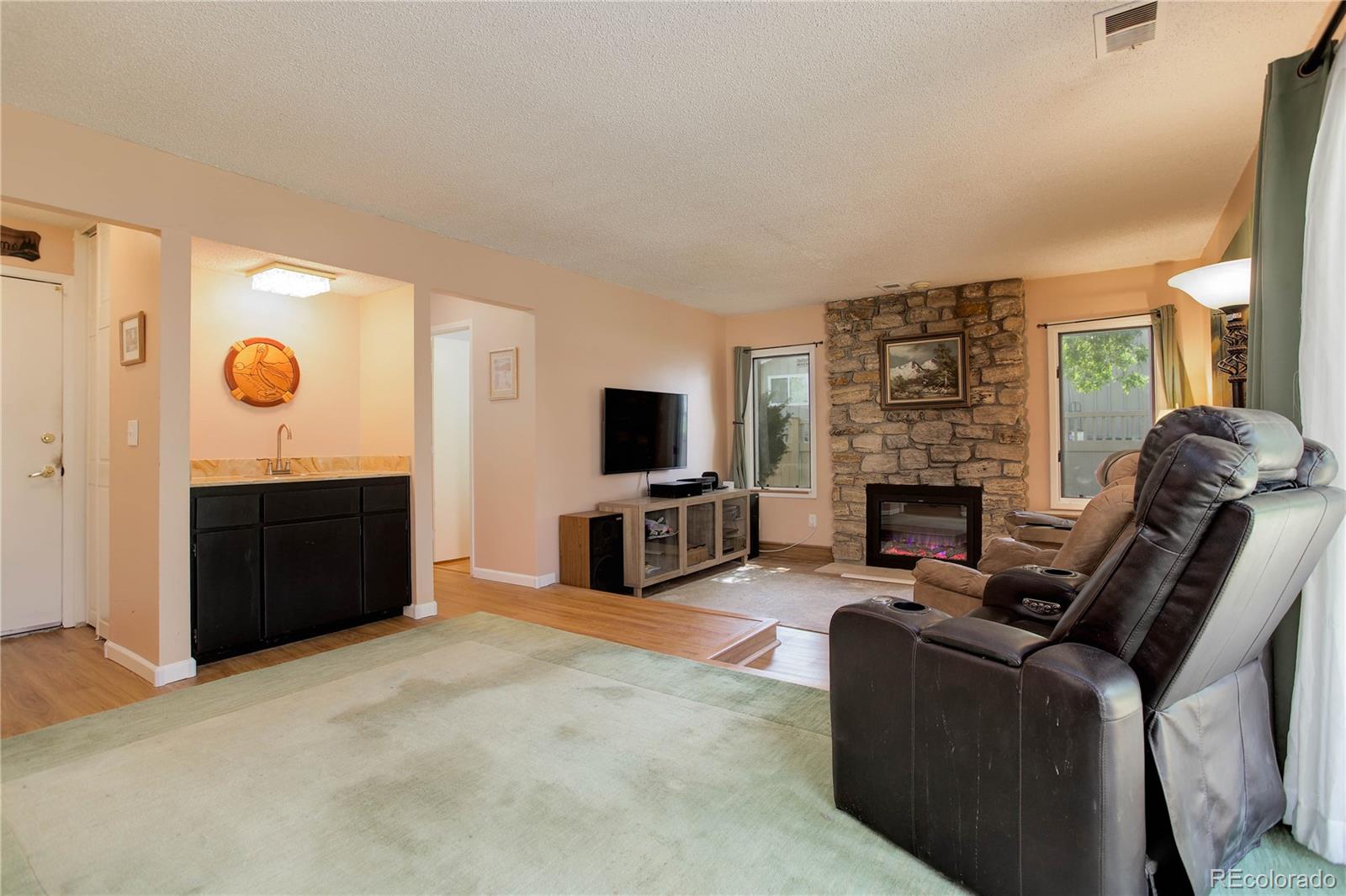 7347 South Ridgeview Drive Littleton, CO 80120 - Photo 14 of 36 a living room with furniture a fireplace and a flat screen tv