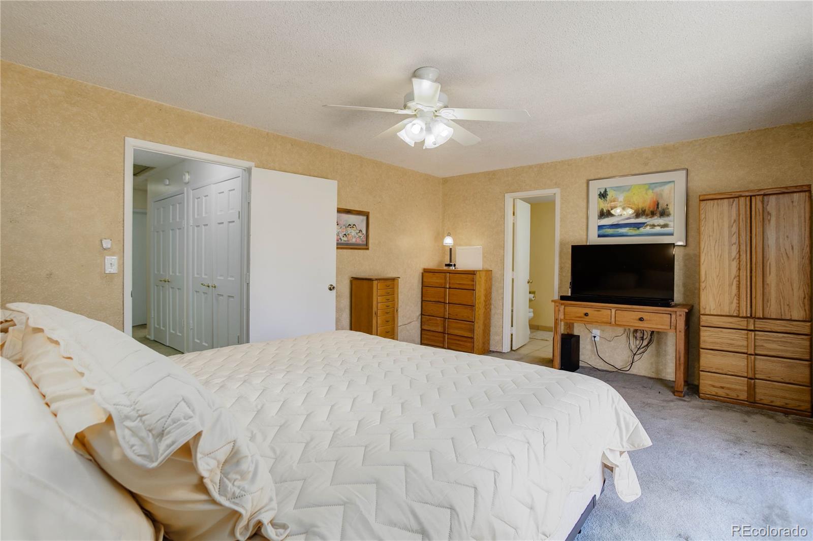 7347 South Ridgeview Drive Littleton, CO 80120 - Photo 17 of 36 a bedroom with a bed and a flat screen tv