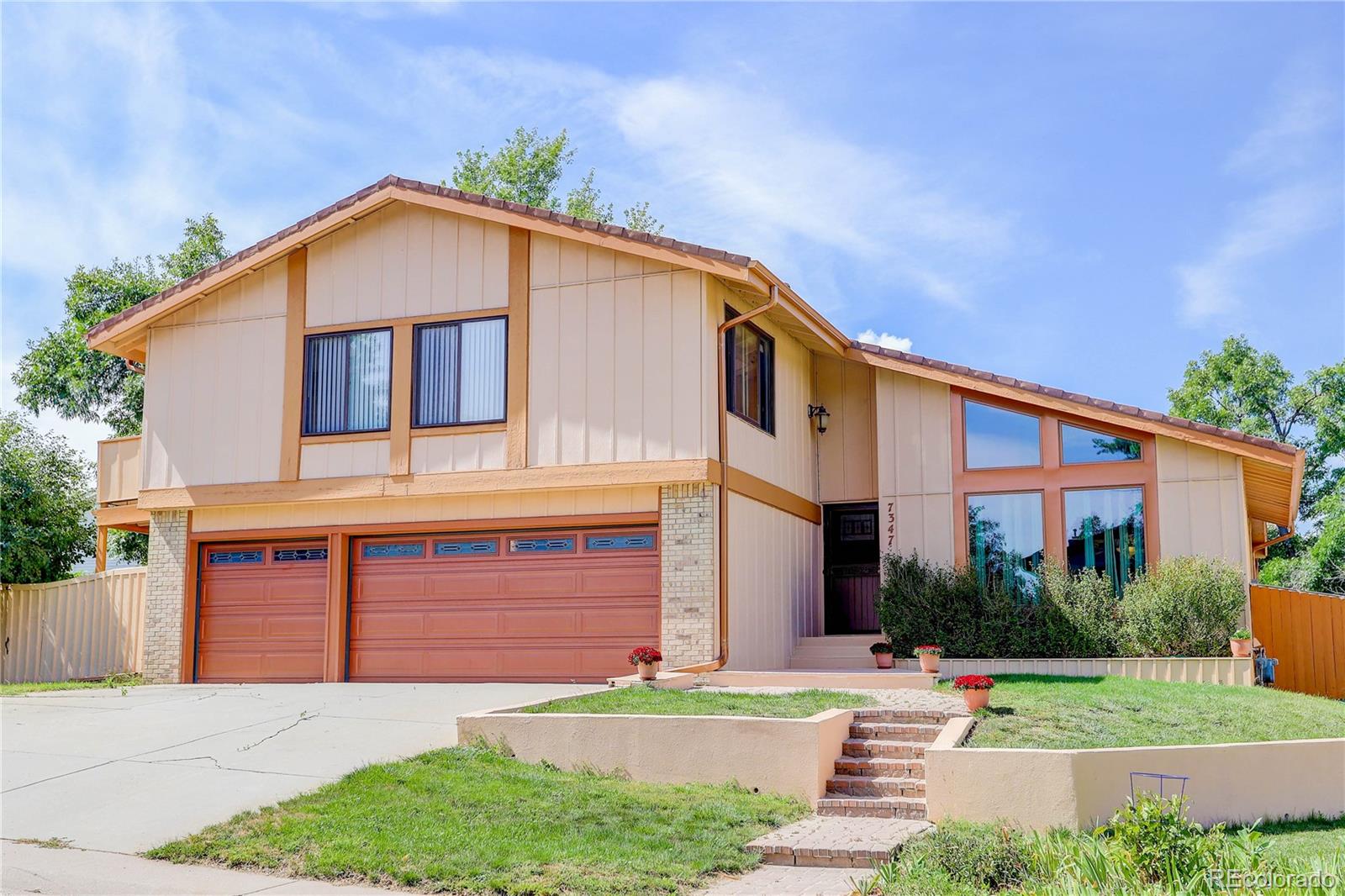 7347 South Ridgeview Drive Littleton, CO 80120 - Photo 2 of 36 a front view of a house with a yard and garage
