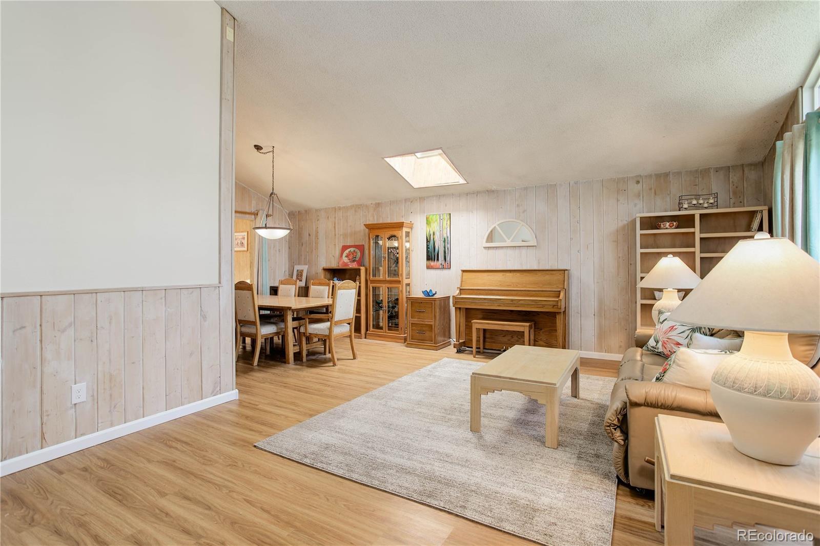7347 South Ridgeview Drive Littleton, CO 80120 - Photo 6 of 36 a living room with furniture and a dining table with kitchen view