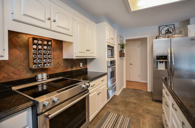 a kitchen with granite countertop a stove microwave and a refrigerator
