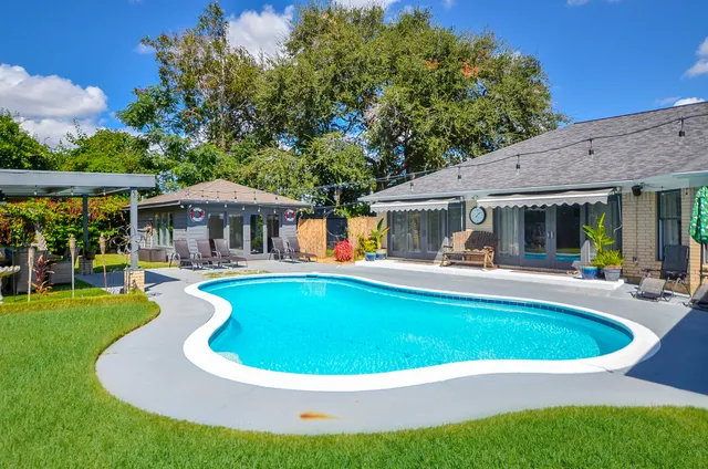 a view of swimming pool and sitting area in the backyard