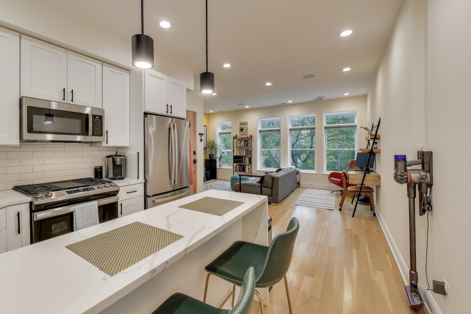 1811 South Laflin Street, Unit 2 Chicago, IL 60608 - Photo 6 of 20 a kitchen with stainless steel appliances granite countertop a refrigerator stove microwave and white cabinets