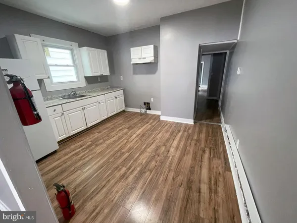 a kitchen with white cabinets appliances and a window