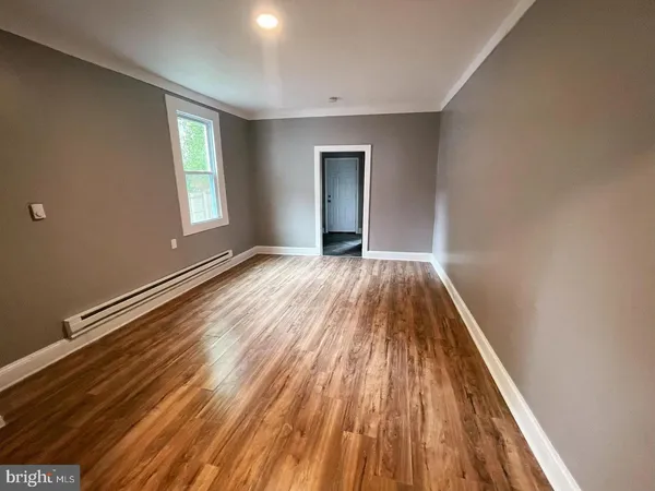 a view of a room with wooden floor and window