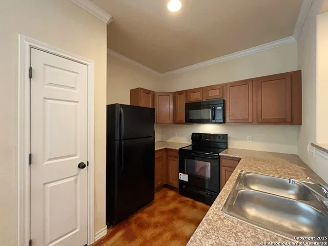 a kitchen with granite countertop stainless steel appliances a refrigerator and a stove top oven