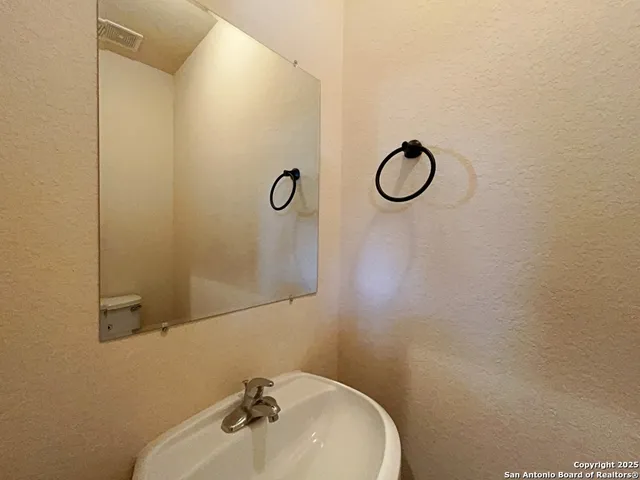 a bathroom with a sink a toilet and mirror