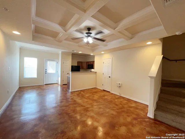 a view of empty room with wooden floor and ceiling fan