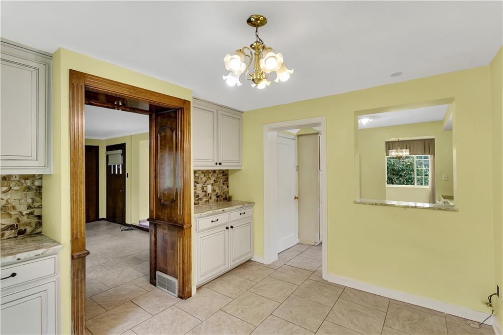 767 Beulah Road Pittsburgh, PA 15235 - Photo 16 of 25 a view of a hallway with wooden floor and a chandelier