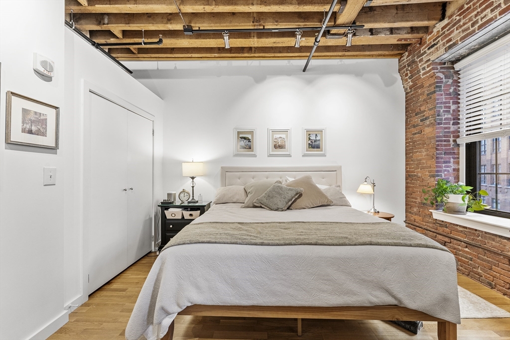 101 Broad Street, Unit 3B Boston, MA 02110 - Photo 11 of 19 a bed sitting in a bedroom next to a window