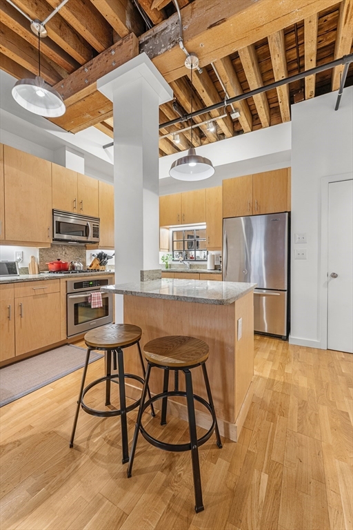 101 Broad Street, Unit 3B Boston, MA 02110 - Photo 2 of 19 a kitchen with stainless steel appliances granite countertop a stove a sink and a refrigerator