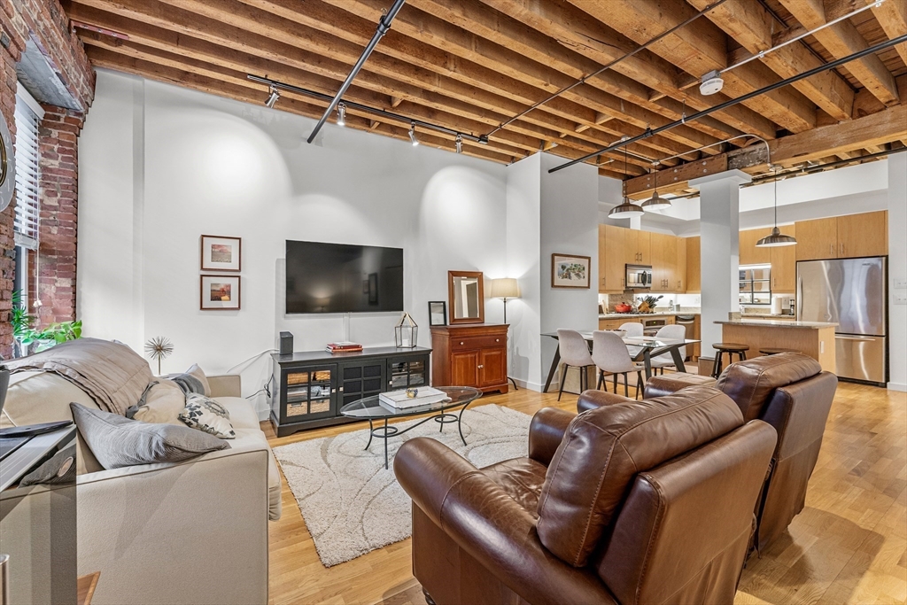 101 Broad Street, Unit 3B Boston, MA 02110 - Photo 4 of 19 a living room with furniture and a flat screen tv