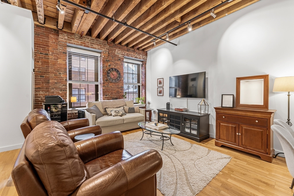 101 Broad Street, Unit 3B Boston, MA 02110 - Photo 6 of 19 a living room with furniture and a flat screen tv