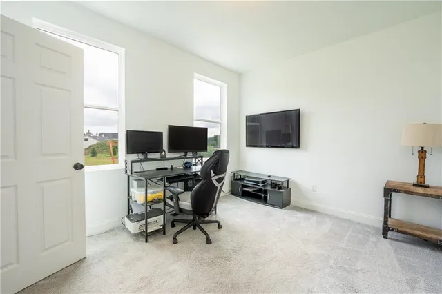a view of a workspace with furniture and a window