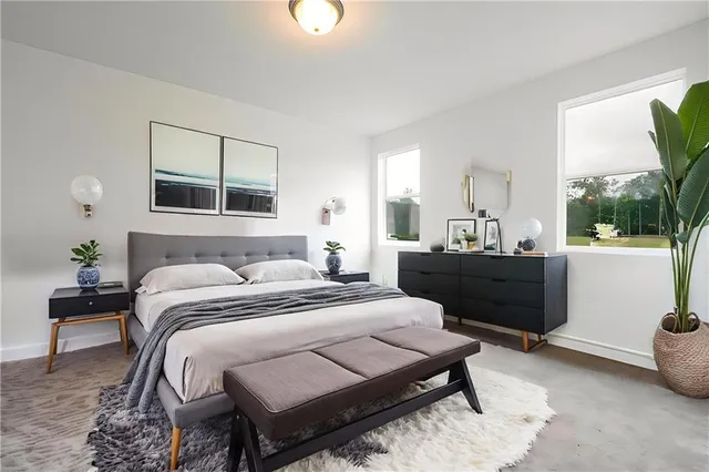 a bedroom with a bed table and a window