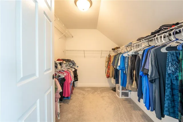 a view of walk in closet with clothes