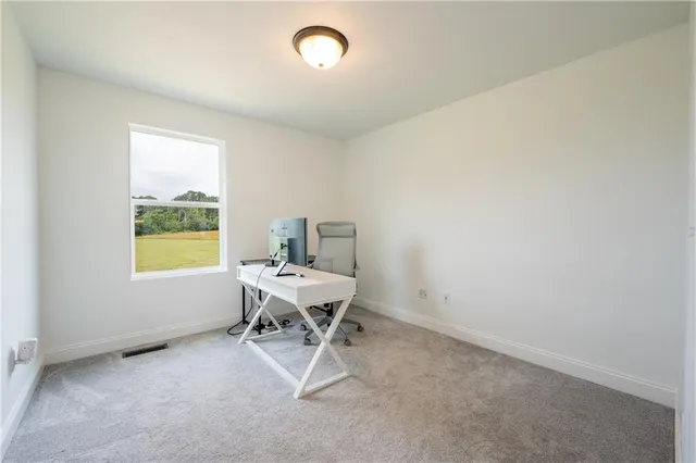 a view of a workspace with furniture and a window