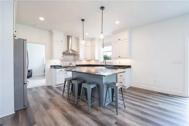 a kitchen with kitchen island a stove a chandelier and a wooden floor