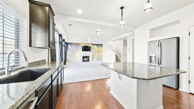 a kitchen with stainless steel appliances granite countertop a sink a stove and a refrigerator