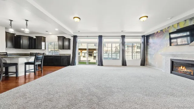 a living room with stainless steel appliances furniture a fireplace and a flat screen tv