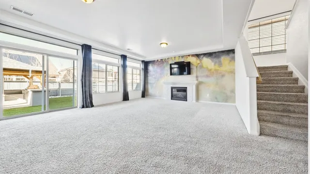 a view of empty room with fireplace and windows